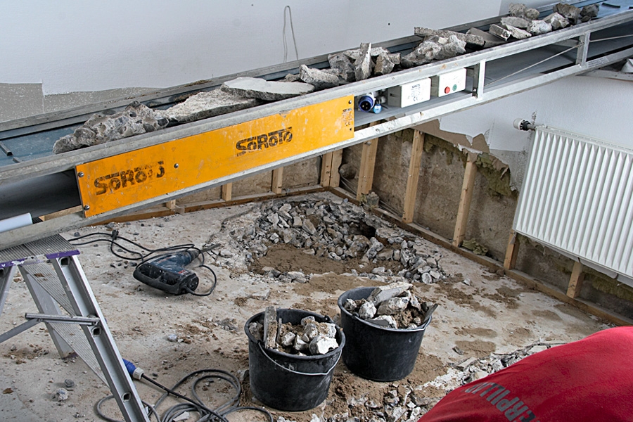 Du kan använda hela semestern på att gräva ut i källaren och sedan bära upp betong och jord i 10-litershinkar uppför trappan, genom hallen och ut genom trädgården. Eller också låter du ett transportband köra bort allt uppgrävt material genom ett källarfönster och ut till en container. Du kan använda hela semestern på att gräva ut i källaren och sedan bära upp betong och jord i 10-litershinkar uppför trappan, genom hallen och ut genom trädgården. Eller också låter du ett transportband köra bort allt uppgrävt material genom ett källarfönster och ut till en container.