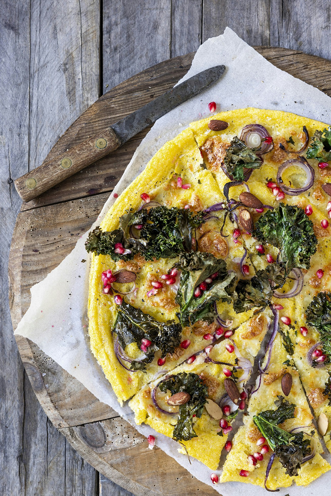 Polentapizza med sprød grønkål, mandler og granatæble | bobedre.dk