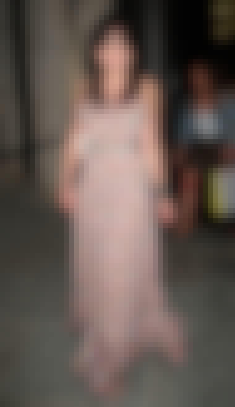 Modellen Daisy Lowe har sat et bælte i taljen på sin gulvlange kjole.