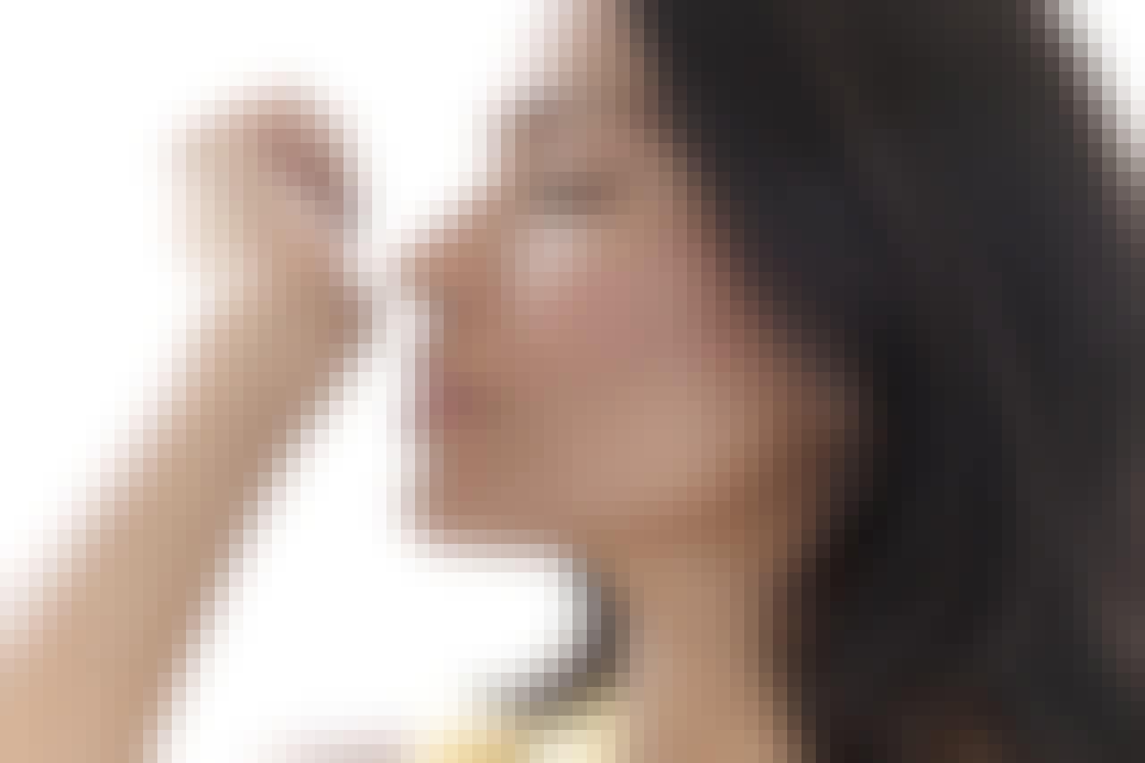 Woman smelling perfume on her wrist