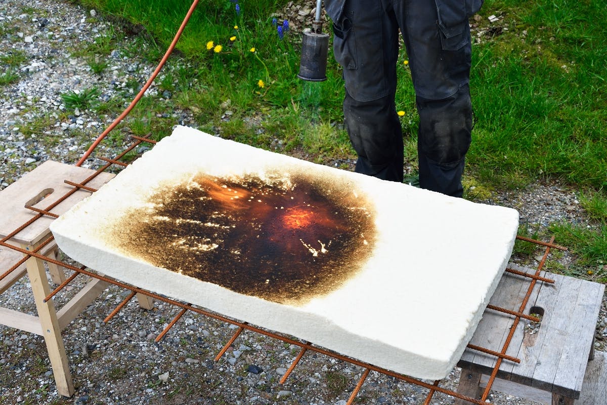 Efter 10 minuter var träfiberskivan svart, men lågan hade inte kommit ner mer än någon centimeter och skivan hade inte ens blivit varm på baksidan.