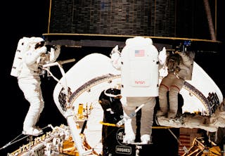 Tre astronauter griber en satellit i vægtløs tilstand, normalt vejer den 4 tons.