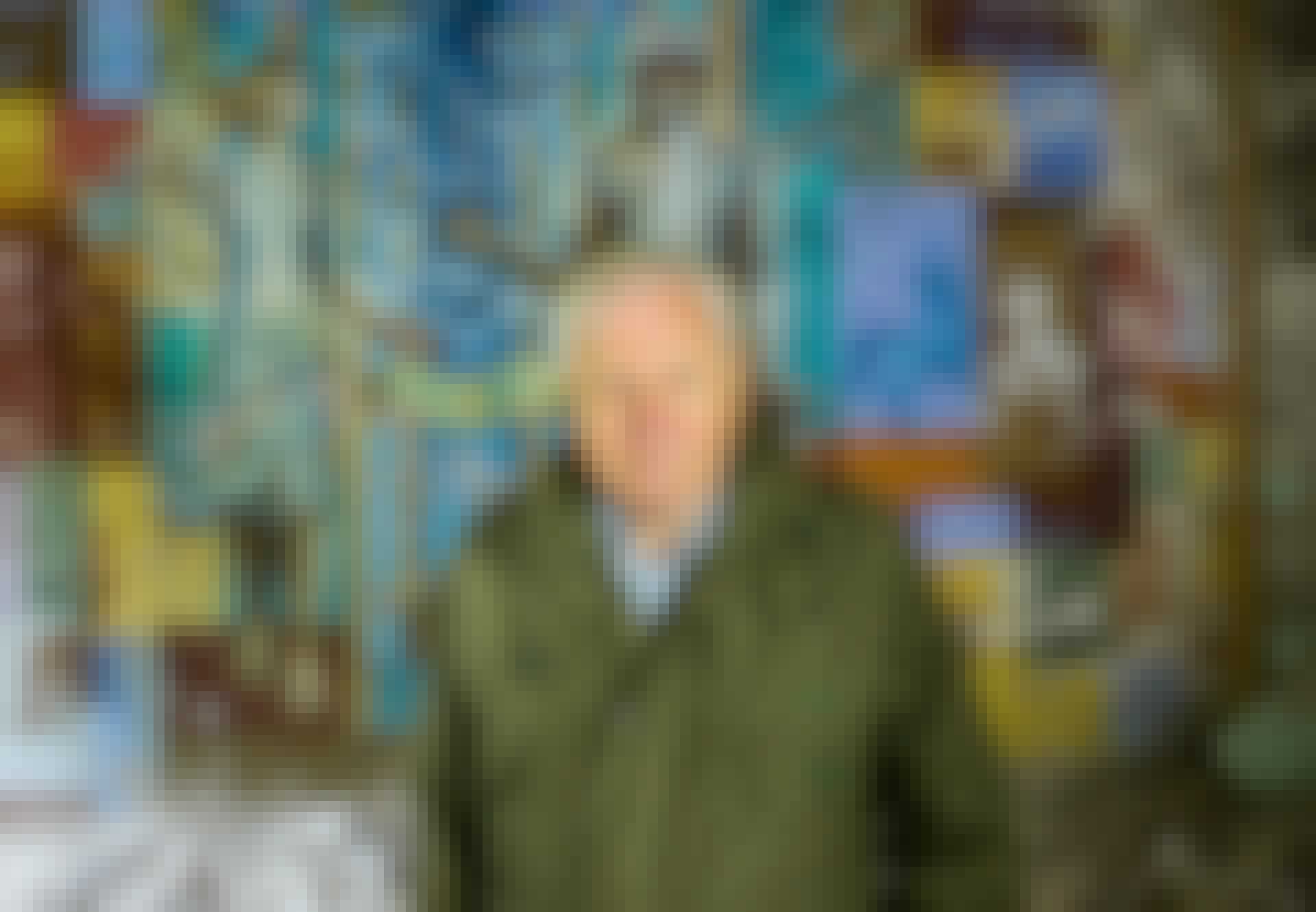 Sir David Attenborough framför en raserad tegelstensmur med grafitti Sir David Attenborough framför en raserad tegelstensmur med grafitti